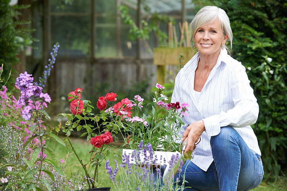 woman working in garden planting flowers