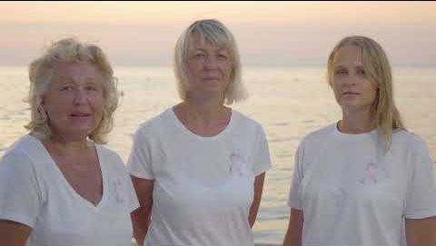 three woman with ocean in the background