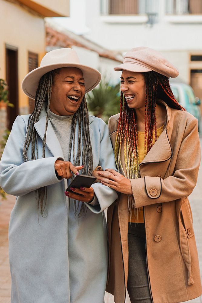 two woman talking while walking in the city